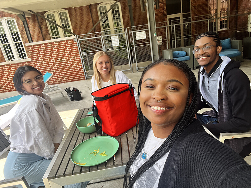 Mission Interns eating lunch at an outdoor picnic table