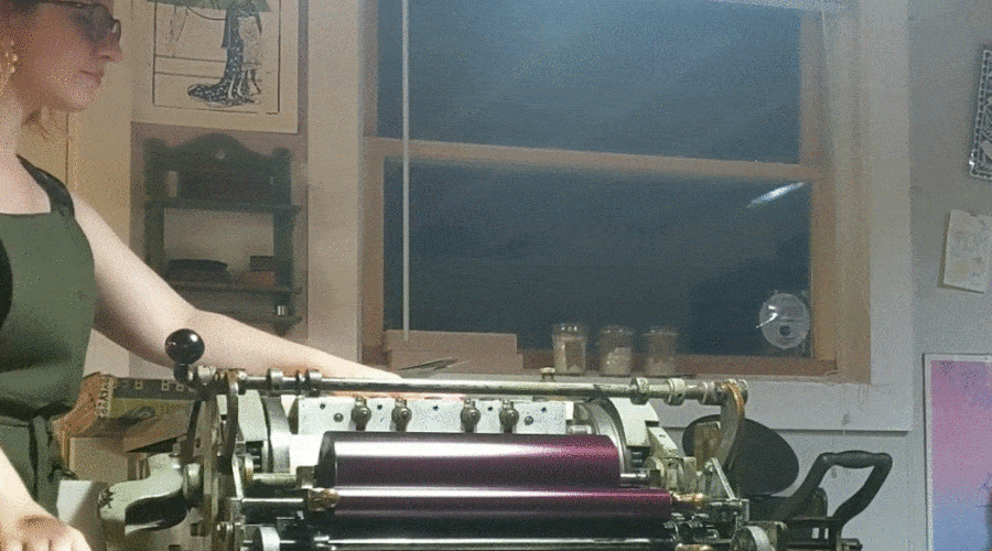 Mission's designer Emilee running prints through a letterpress
