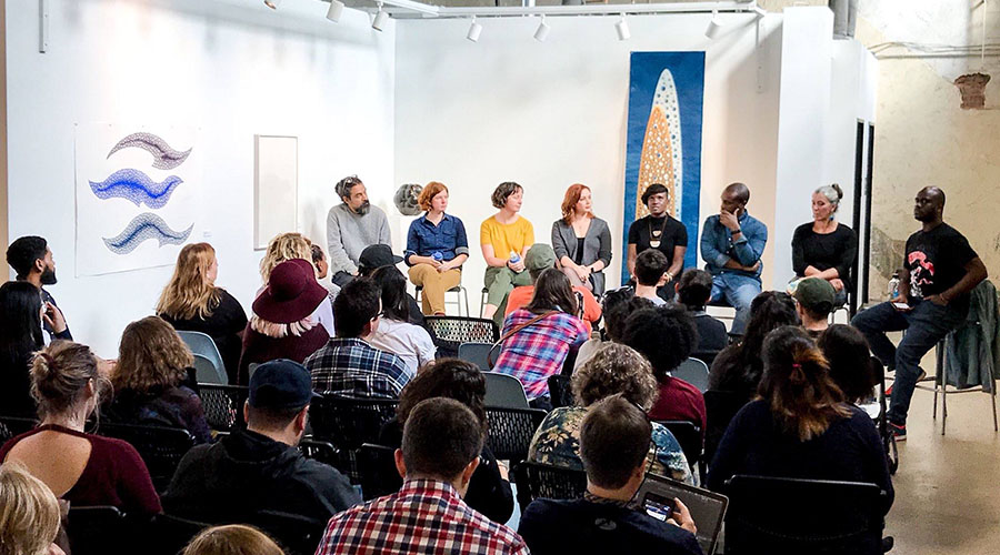 people sitting on chairs listening to eight lecturing designers at the AIGA Design Week