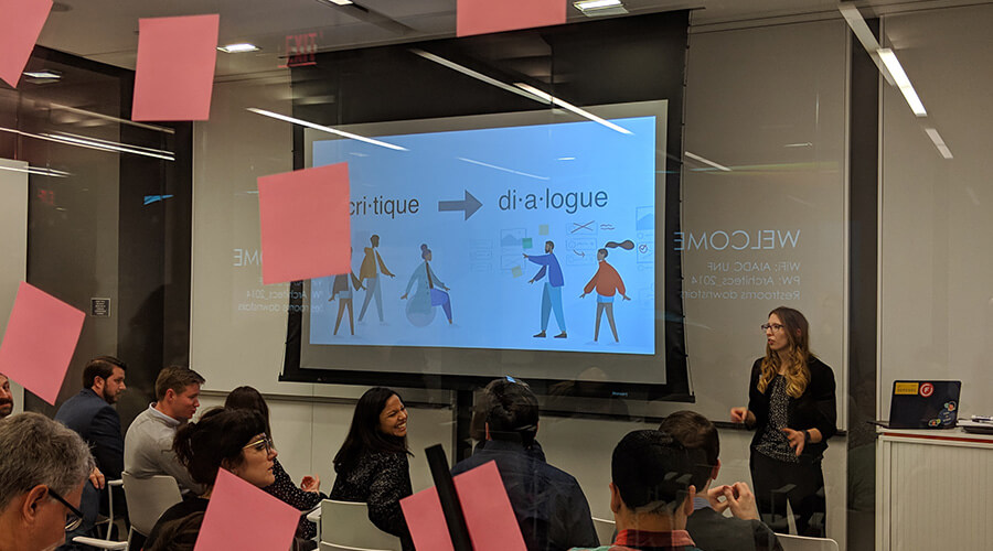 a women leading a ux camp session in front of a large screen