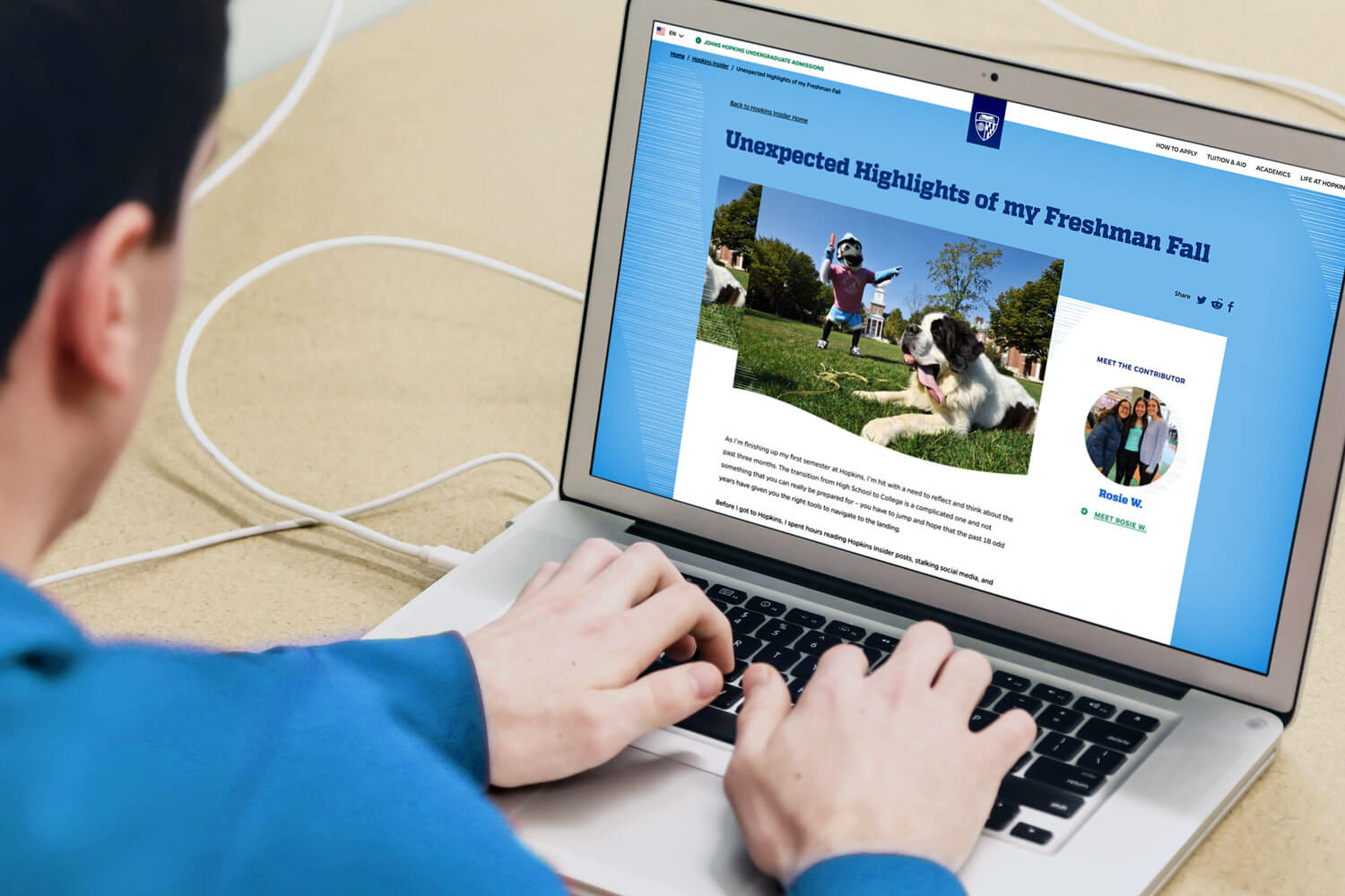 A man in front of a laptop open to a Hopkins Insider blog post.